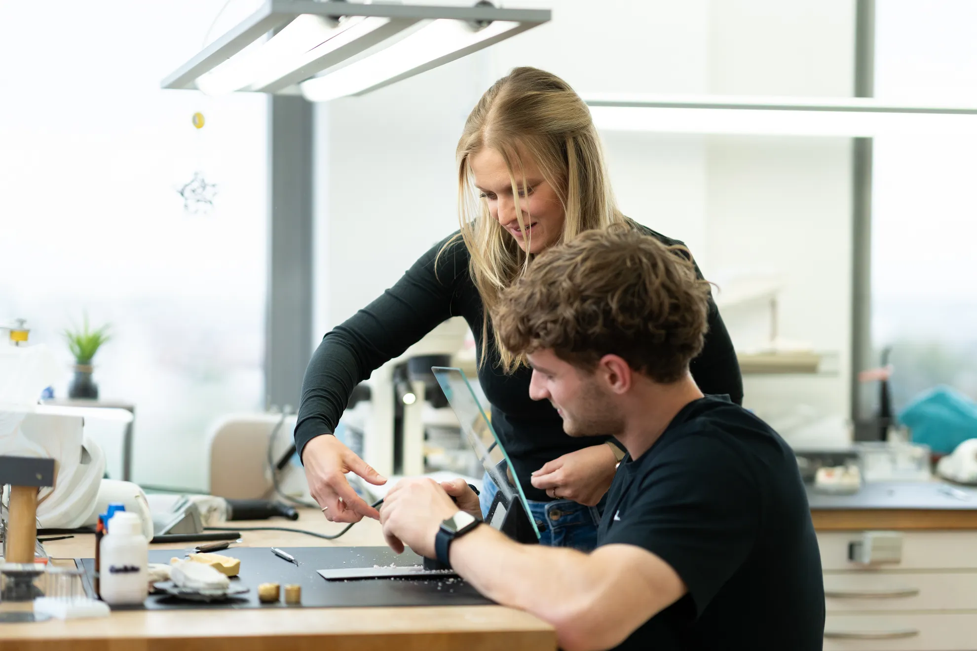 Zwei Personen arbeiten zusammen an einem Zahnmodell